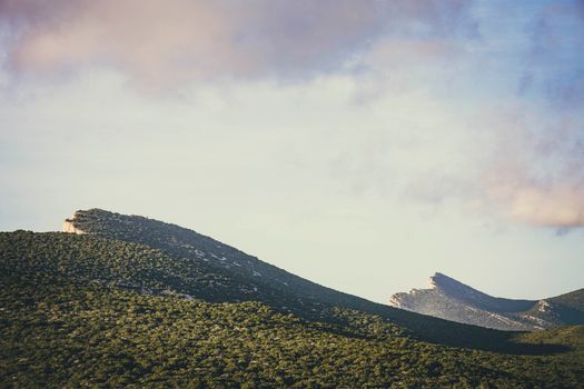 Beautiful mountain view with lush greenery under a cloudy sky at sunset, ideal for nature lovers.