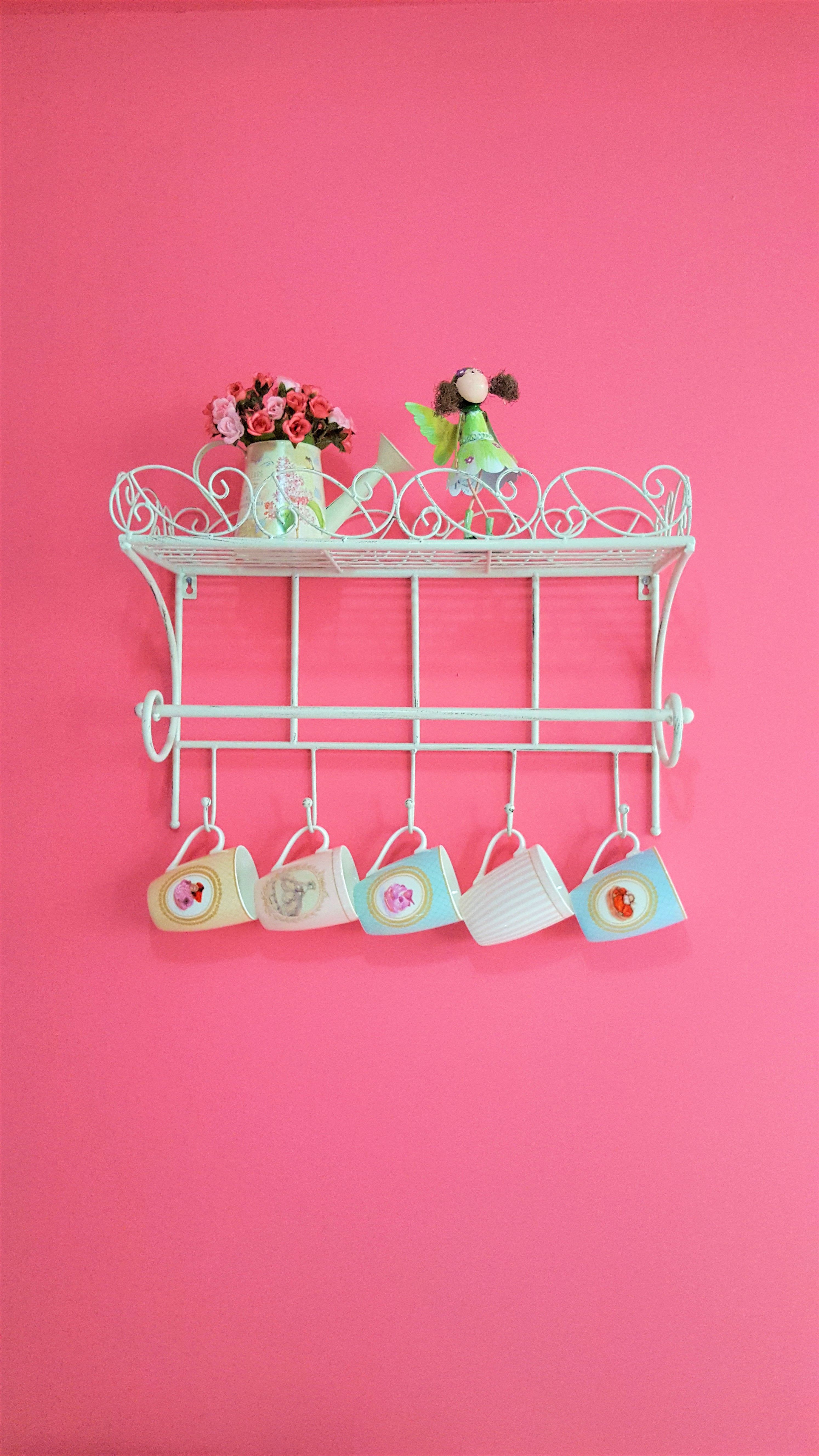 ornate iron vintage mug rack holding colorful ceramic coffee mugs