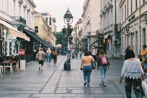 Free Lively street scene with people walking in a historic European city center. Stock Photo