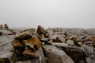 Rough stones on boulders under foggy sky