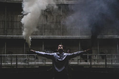 Free Man Performing with Smoke at Straw Construction Theatre Stock Photo
