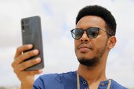 Man in Blue Crew Neck Shirt Holding Silver Iphone 6