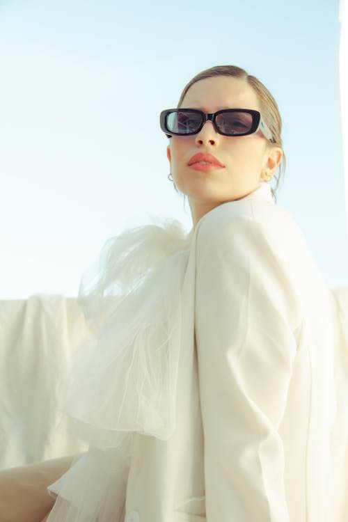 Stylish woman in sunglasses under blue sky