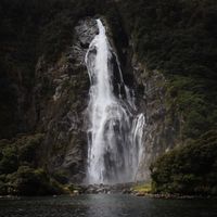 Tall waterfall dropping down a forested granite cliff. Photo by Lawson Davey on Pexels