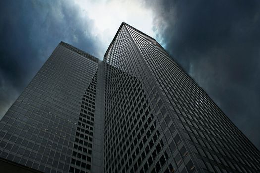 Dramatic view of towering skyscrapers in Montreal with ominous clouds overhead.