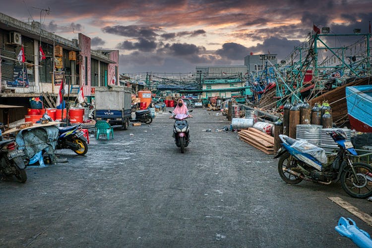 Woman Driving A Motorcycle On A Polluted Area