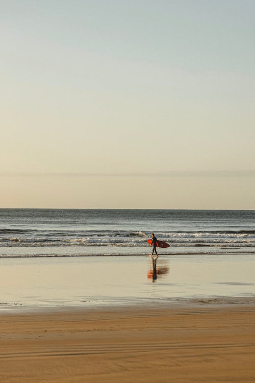  A Surfer at the Beach During Sunrise 