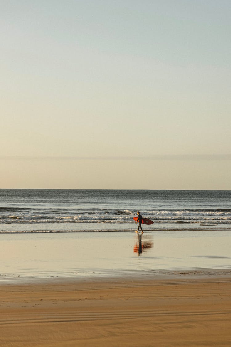  A Surfer At The Beach During Sunrise 