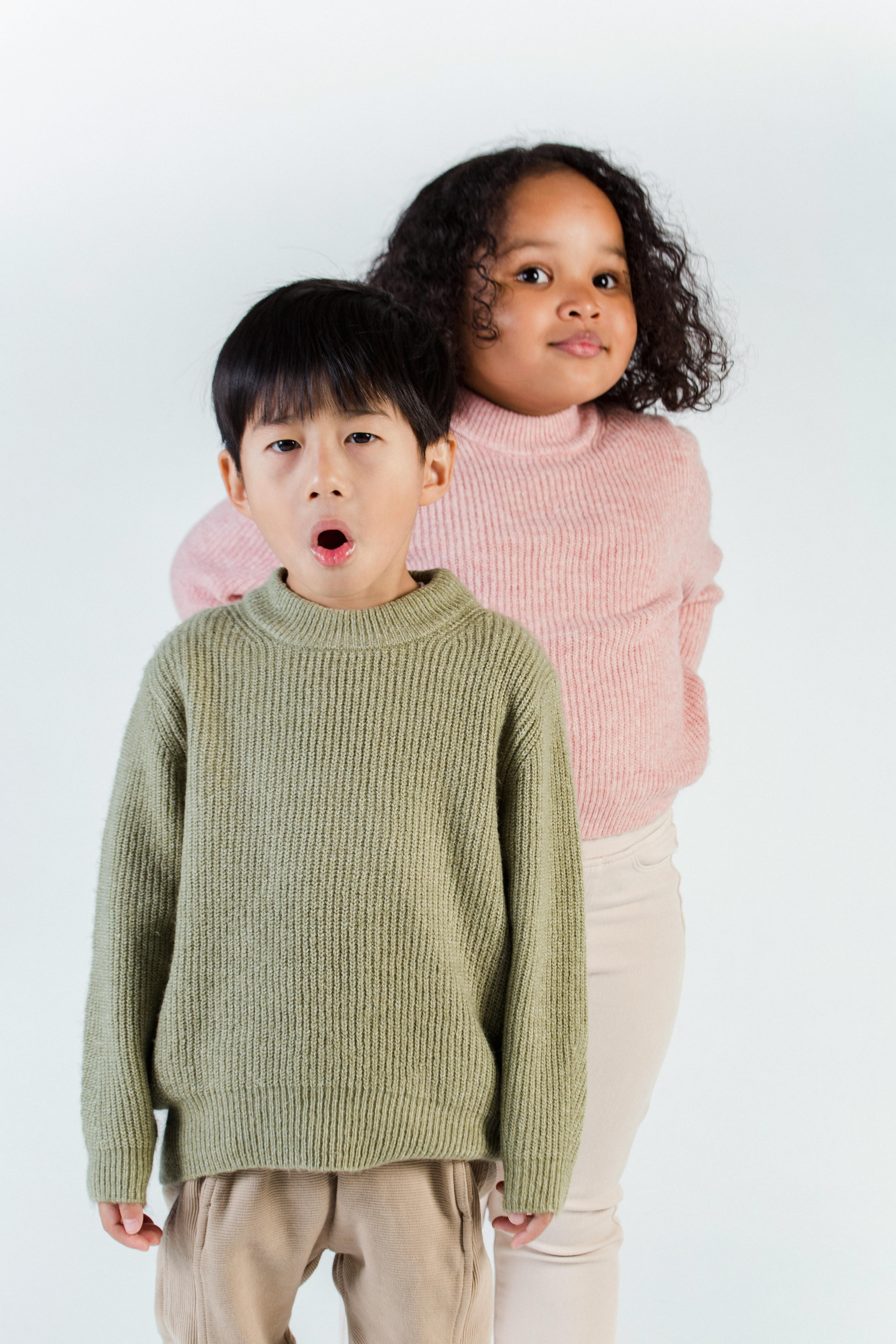 adorable multiethnic kids in warm clothes in studio