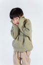 Cute shy ethnic boy in sweater