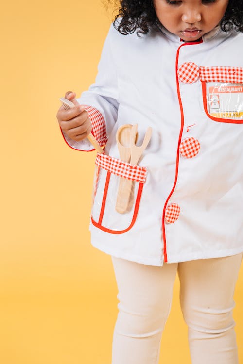 Free Cute black girl in uniform with kitchen accessories Stock Photo