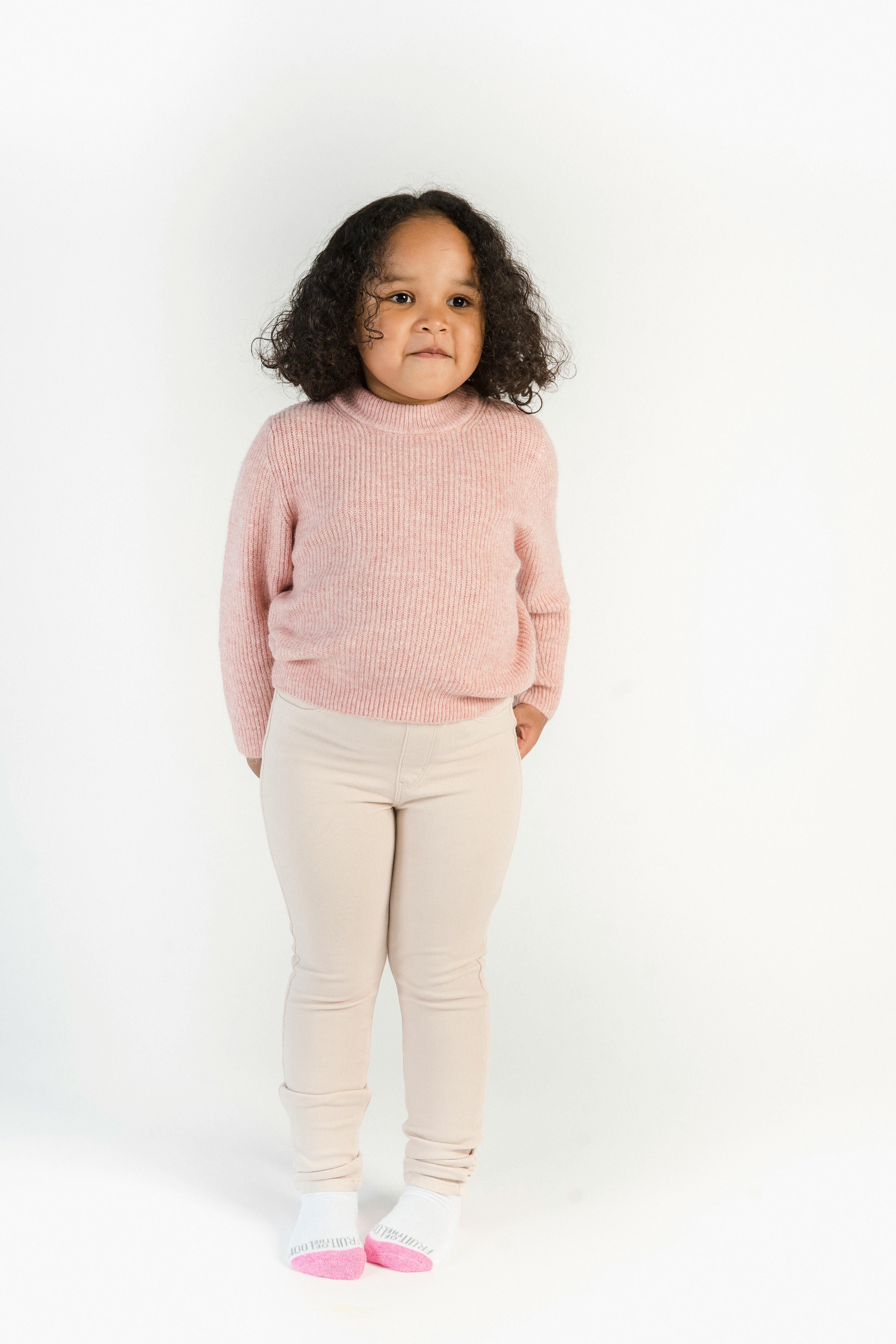 cute black girl in sweater and skinny pants in studio