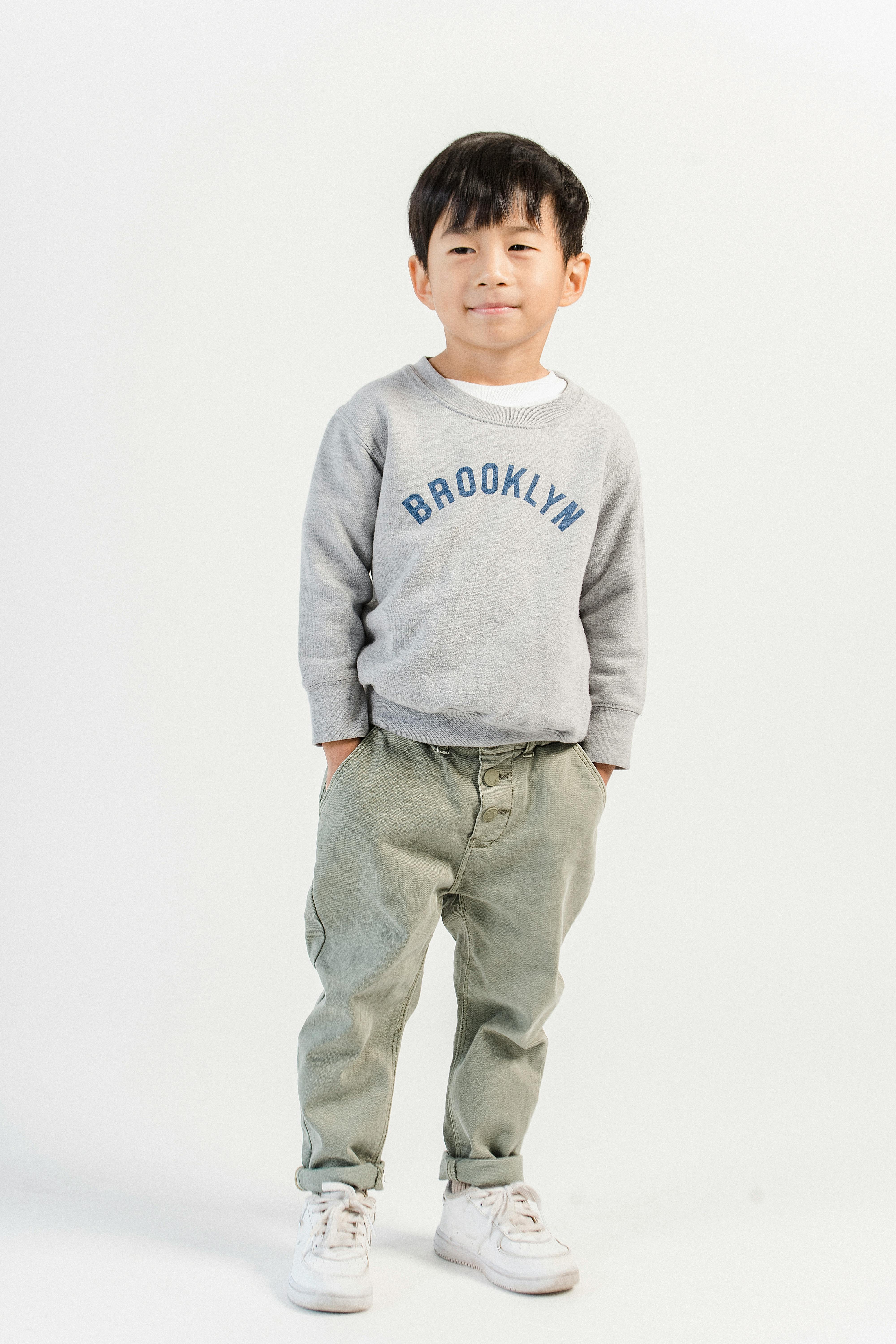 positive ethnic kid in modern clothes in studio