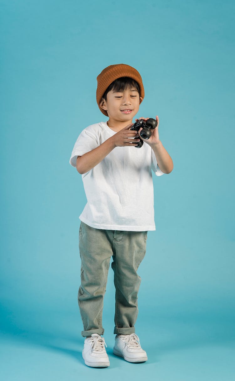 Asian Boy In Trendy Wear With Toy Car