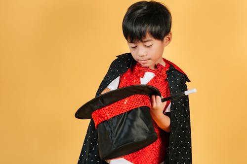 Little Asian boy in costume of magician