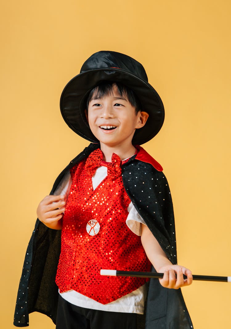 Cheerful Asian Boy In Costume Of Magician With Magic Wand