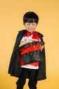 Happy little Asian boy in magician costume doing trick