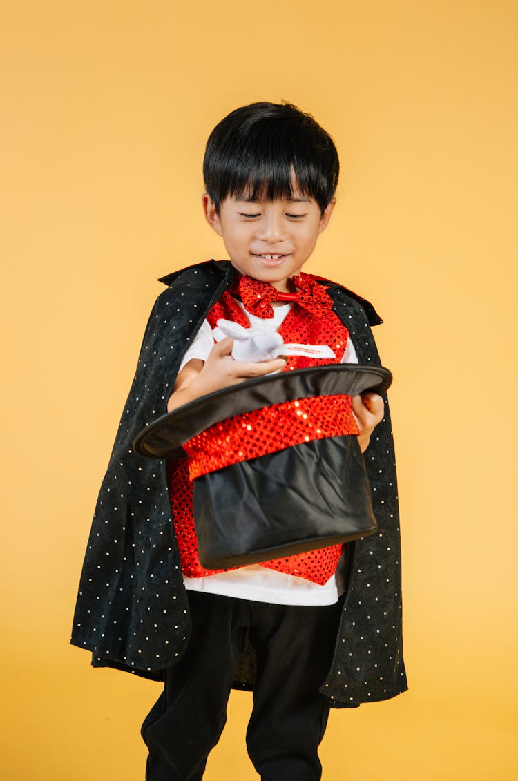 Happy Little Asian Boy In Magician Costume Doing Trick