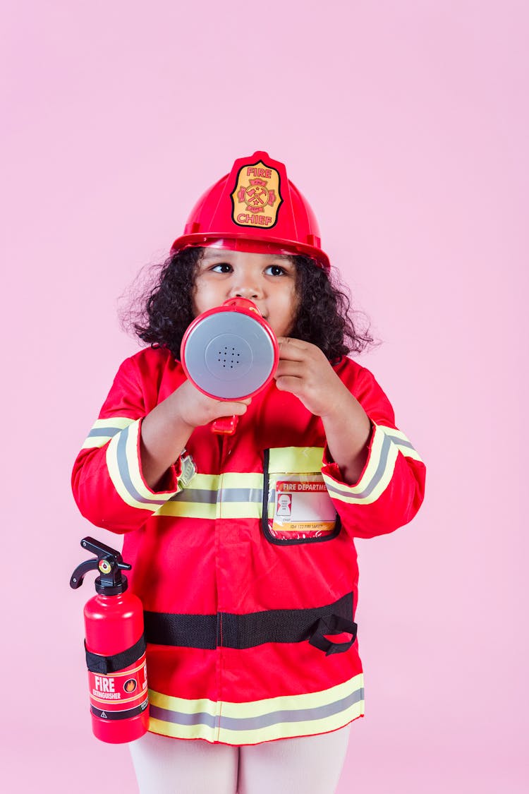 Ethnic Girl Wearing Firefighter Costume Using Megaphone