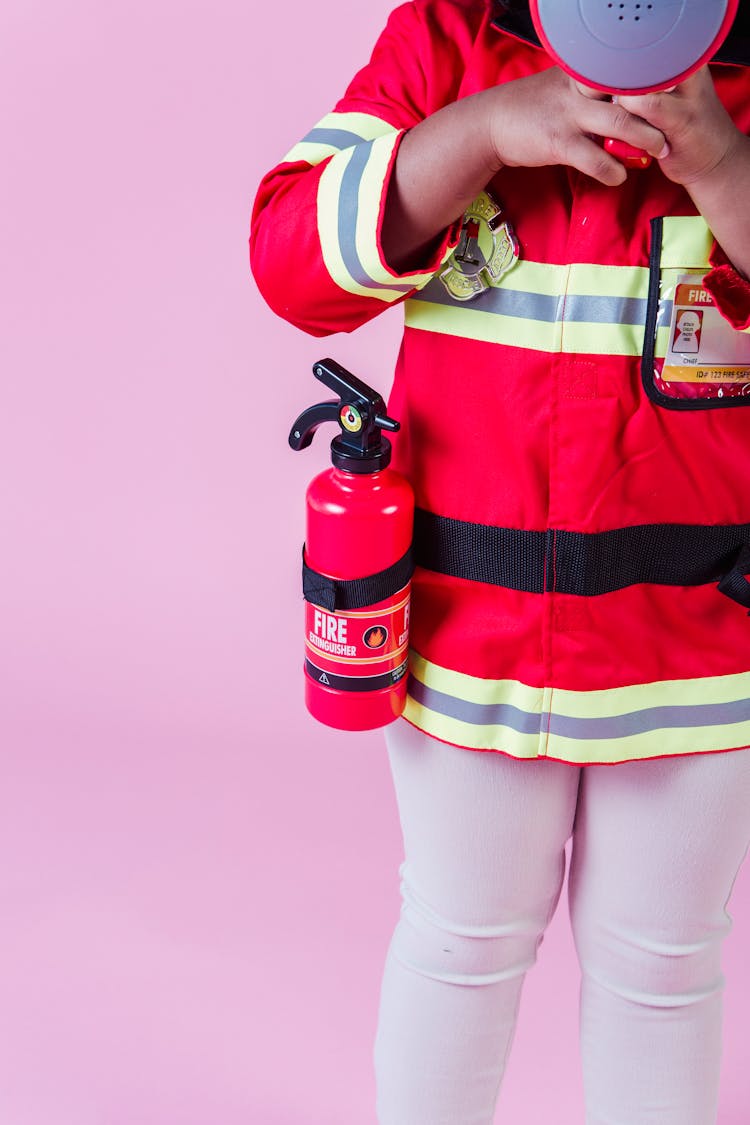 Anonymous Ethnic Kid Wearing Fireman Costume In Studio