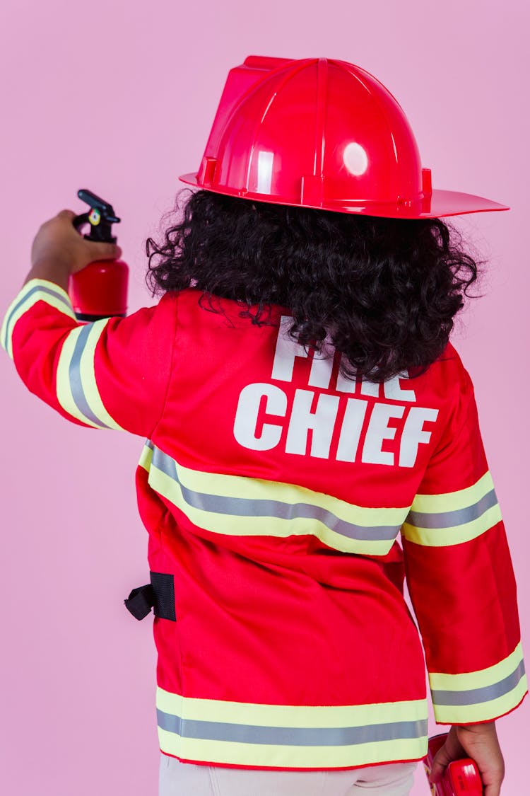 Anonymous Ethnic Kid In Fireman Costume In Studio