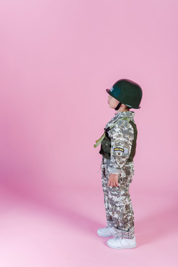 Anonymous Ethnic Boy In Military Uniform In Room