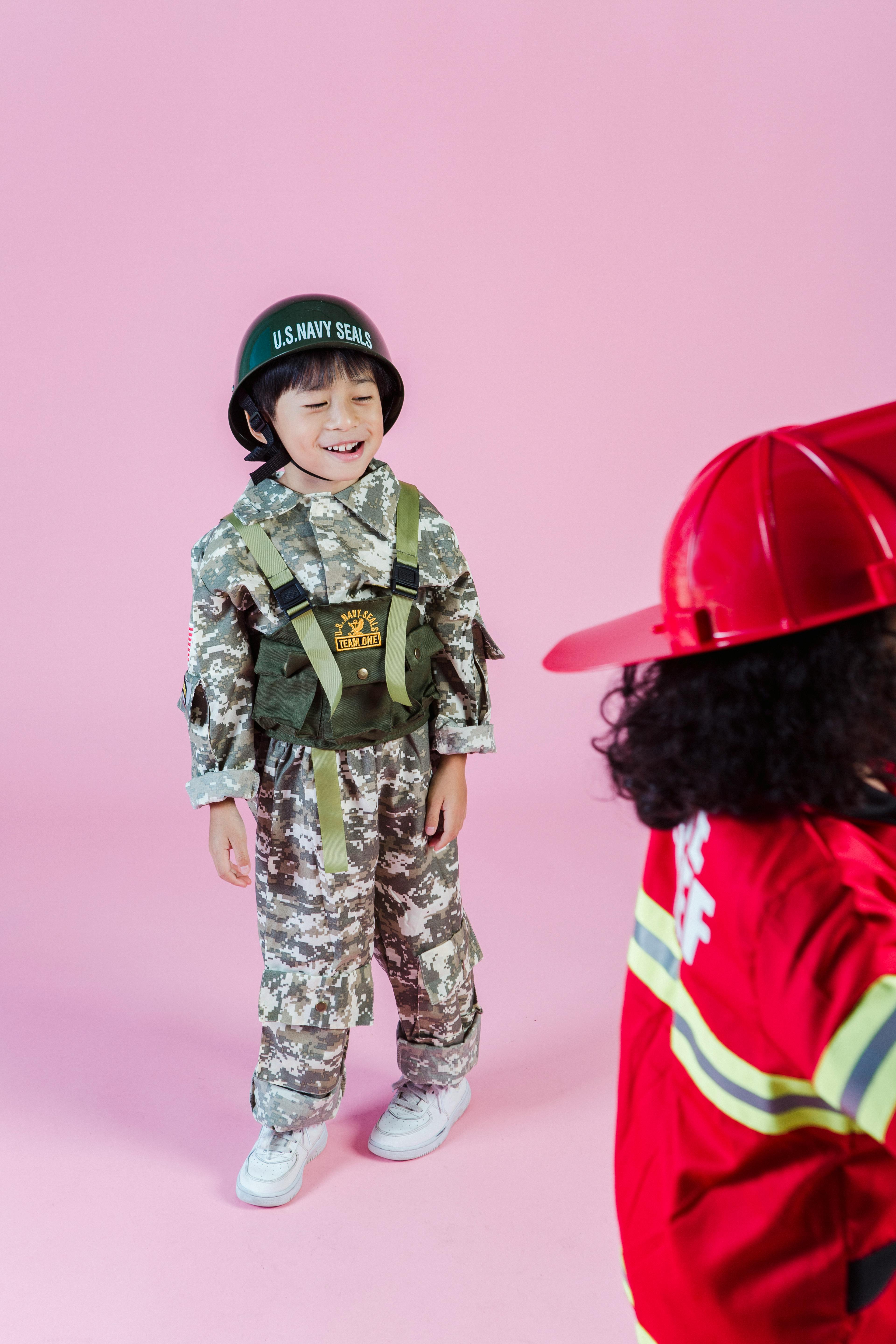 multiracial children in military outfit and fireman costume in studio