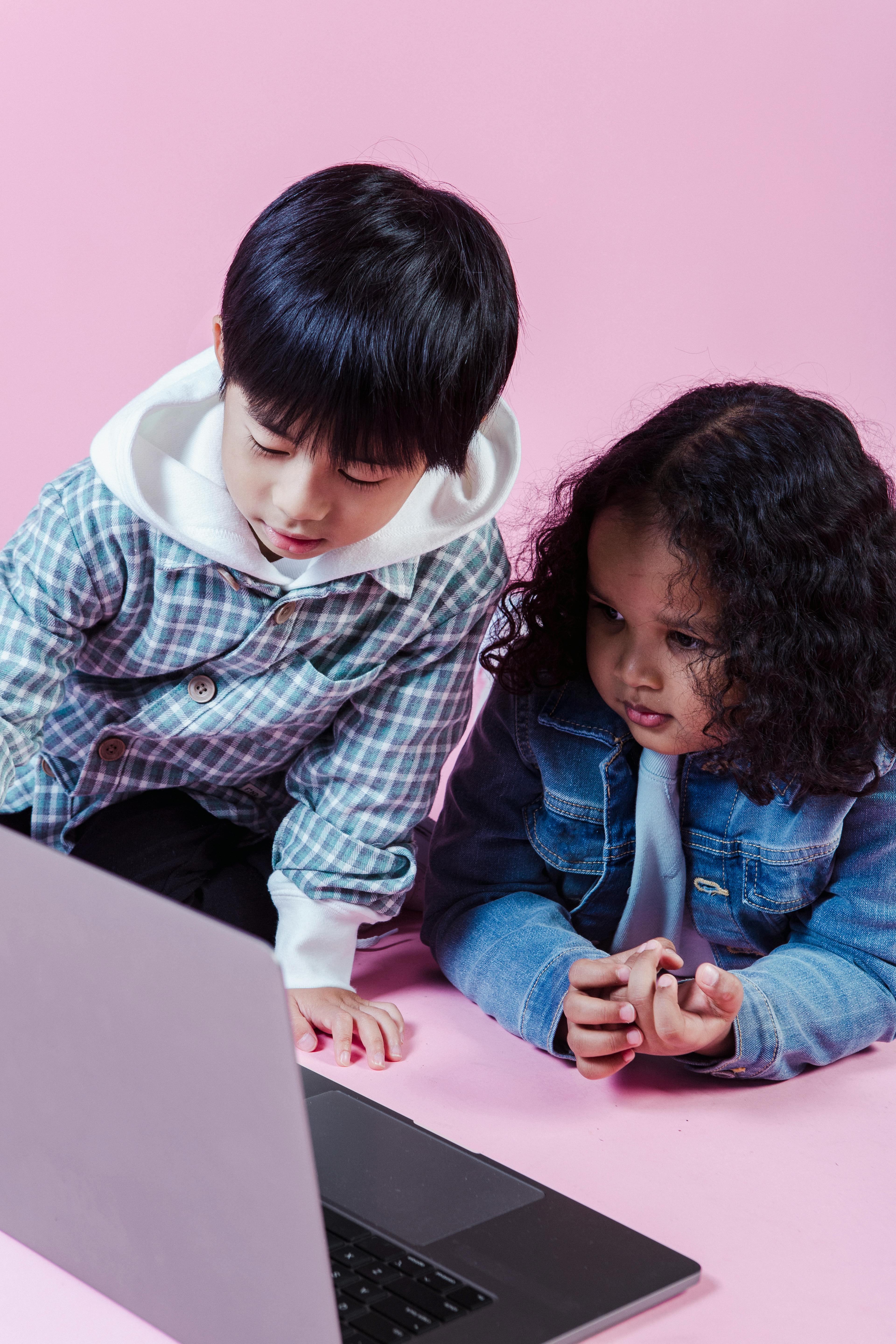 little multiethnic kids using laptop on floor