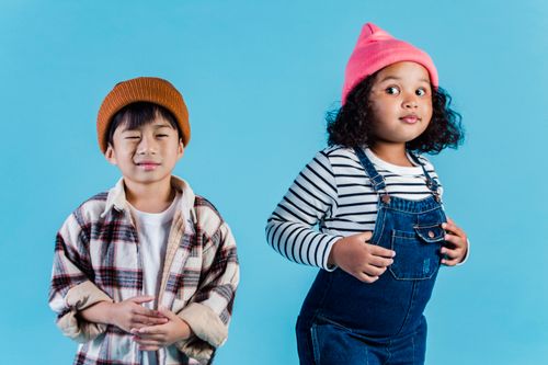 Free Multiethnic kids in casual clothes standing on blue background and making grimace in room Stock Photo