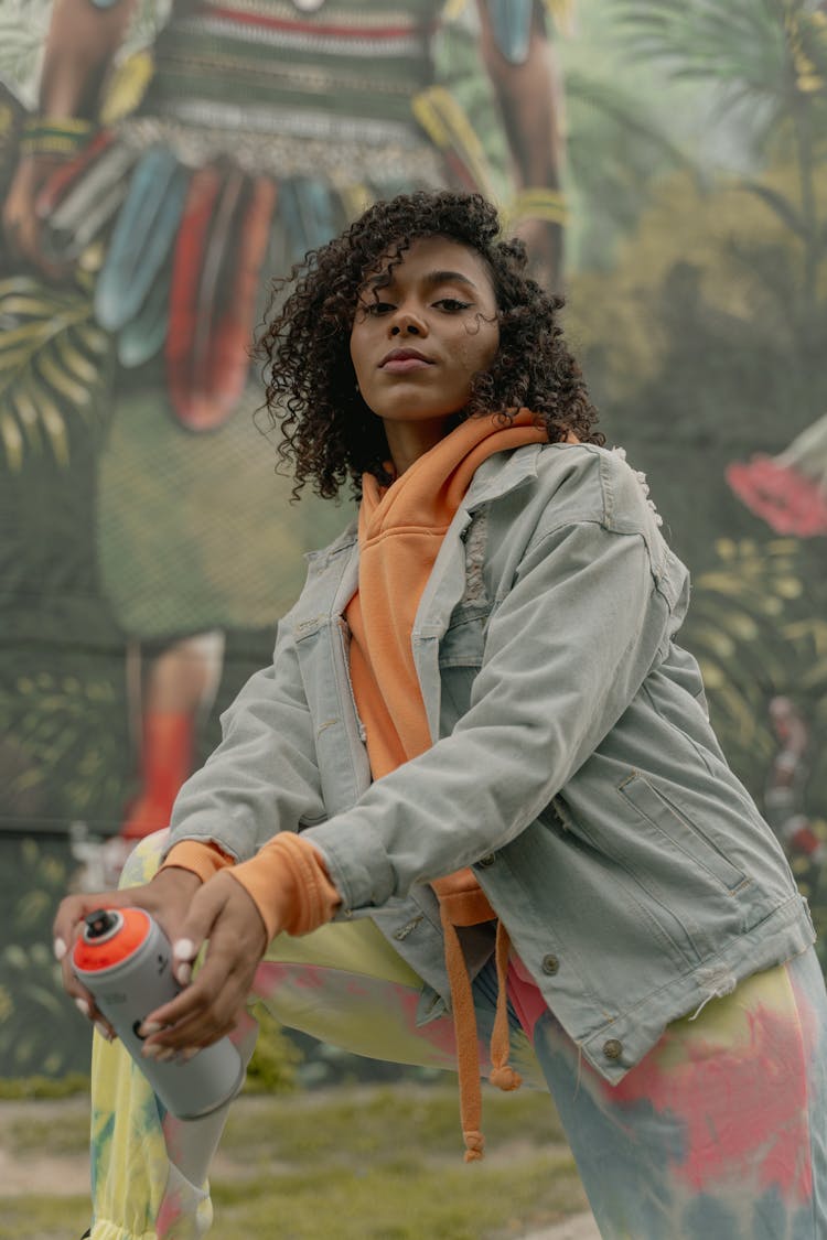 A Woman In Denim Jacket Holding A Spray Can