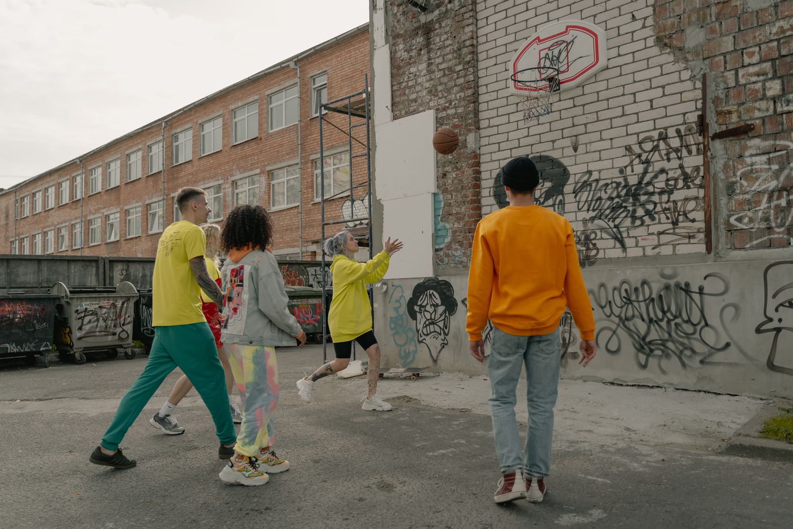Grupo de jogadores em partida de basquete em quadra de rua urbana