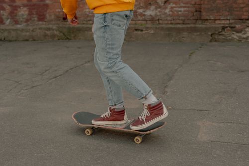 Free Close-up of a person skateboarding outdoors in denim jeans and sneakers. Stock Photo