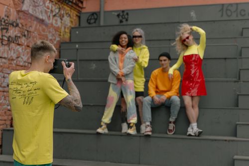 Free Group of friends posing for a street fashion photoshoot against a graffiti wall. Stock Photo