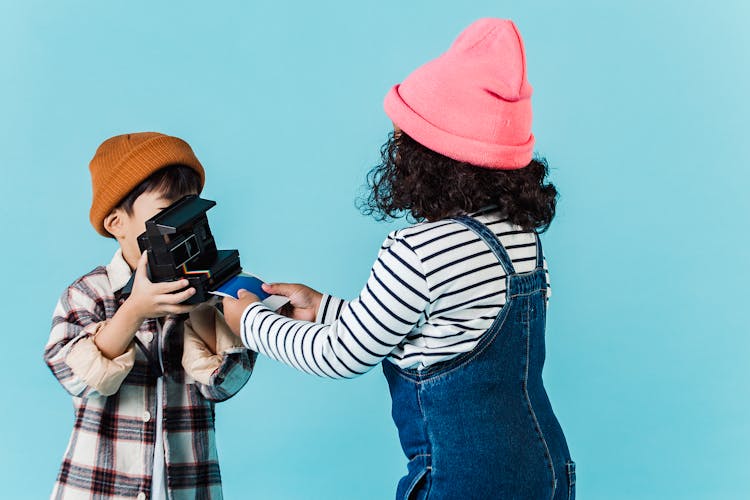 Children Taking Instant Photo On Vintage Camera In Studio