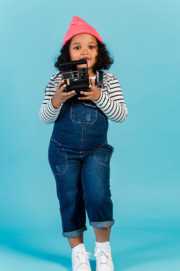 African American Girl Standing With Instant Photo Camera In Studio