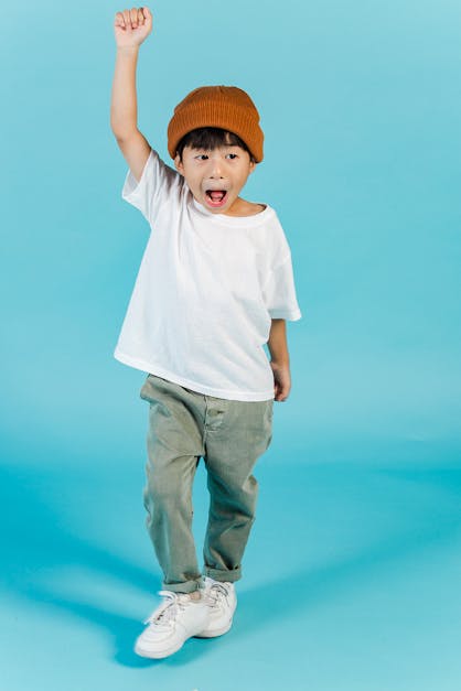 Happy Asian boy with raised arm · Free Stock Photo