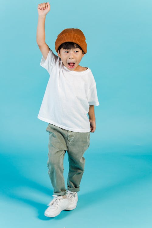 Happy Asian boy with raised arm