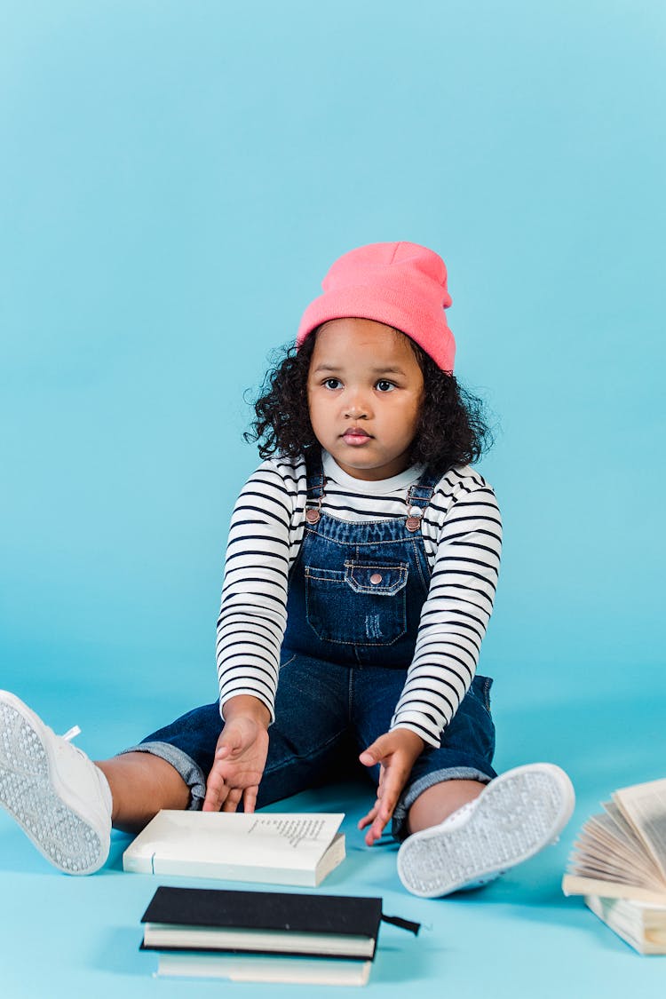 Puzzled Black Girl Sitting With Books