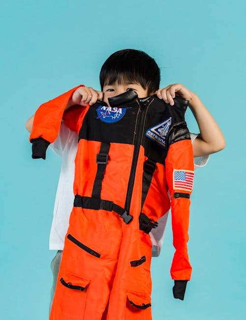 Anonymous Asian kid with spacesuit in hands