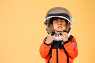 Asian kid wearing astronaut helmet