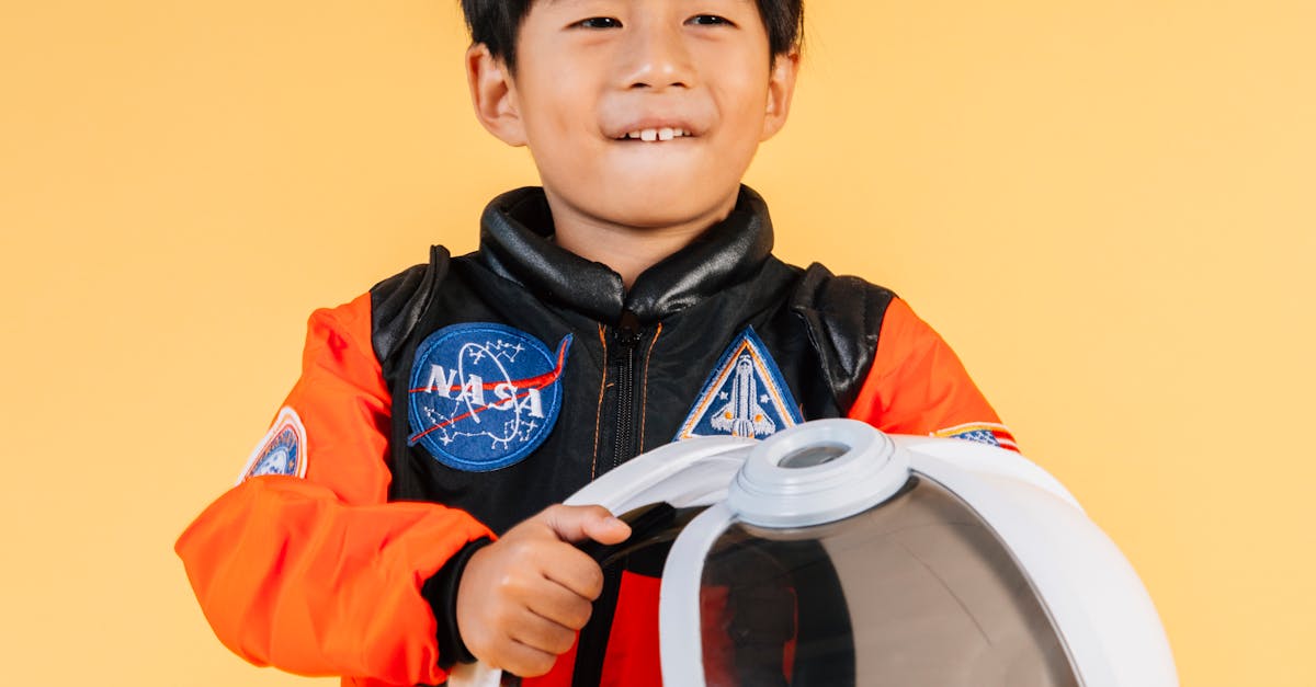 Cheerful Asian boy with astronaut helmet · Free Stock Photo