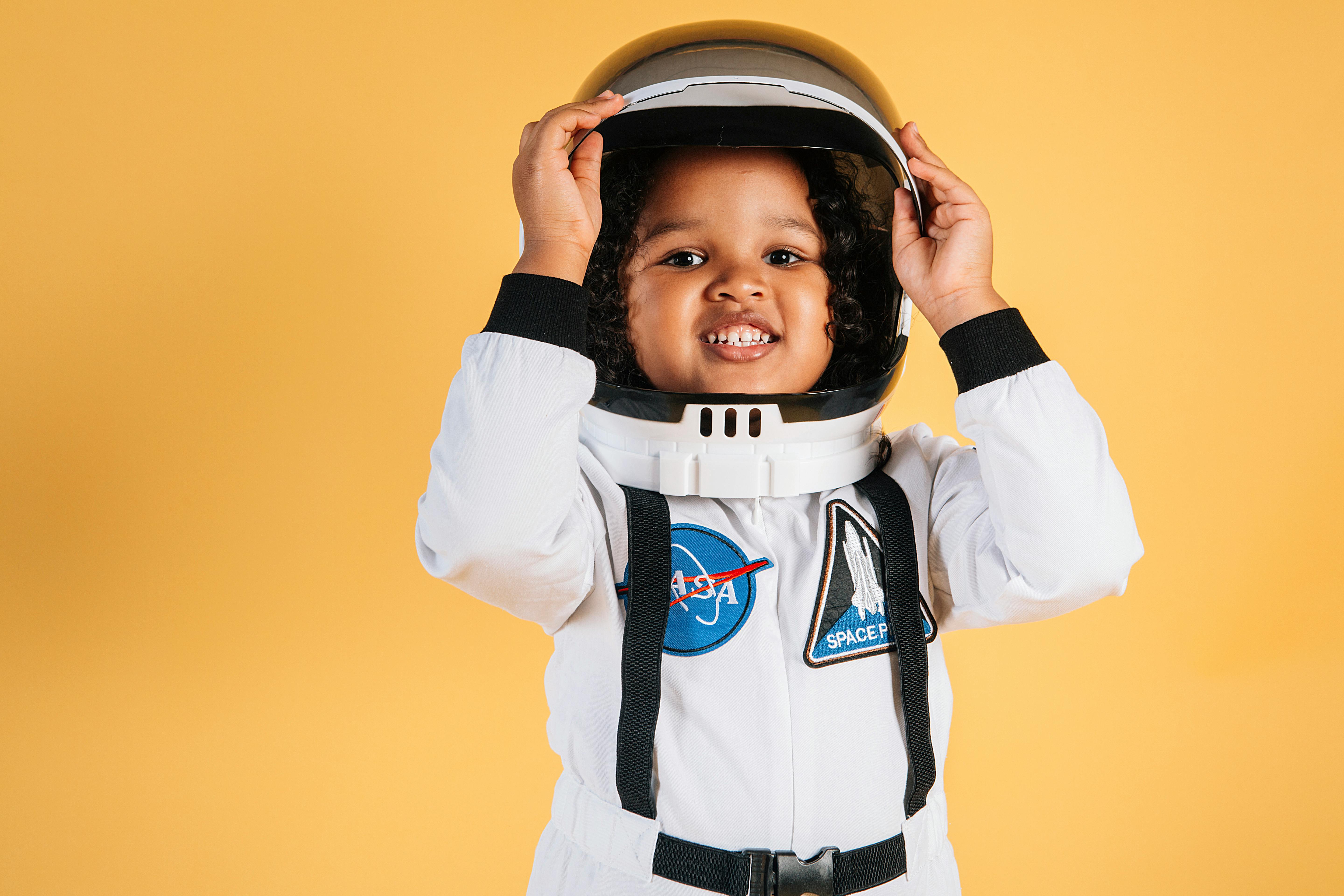 cheerful ethnic girl in white space suit