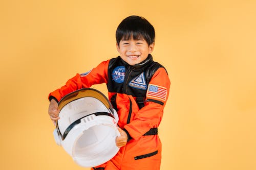 Cheerful little ethnic kid in space suit