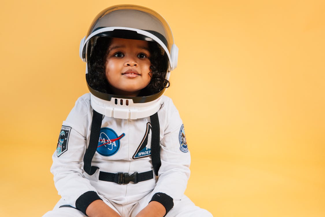 Calm little girl wearing space suit · Free Stock Photo