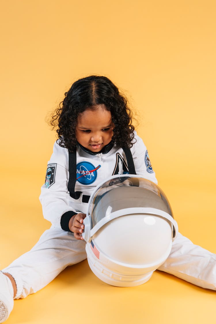 Focused Ethnic Girl With Spacesuit Helmet