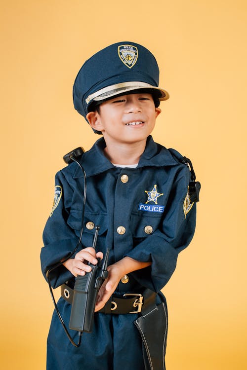 검은 소총을 들고 파란색 경찰 제복을 입은 소년