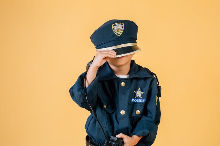 Anonymous Kid In Police Uniform Pulling Cap Over Face