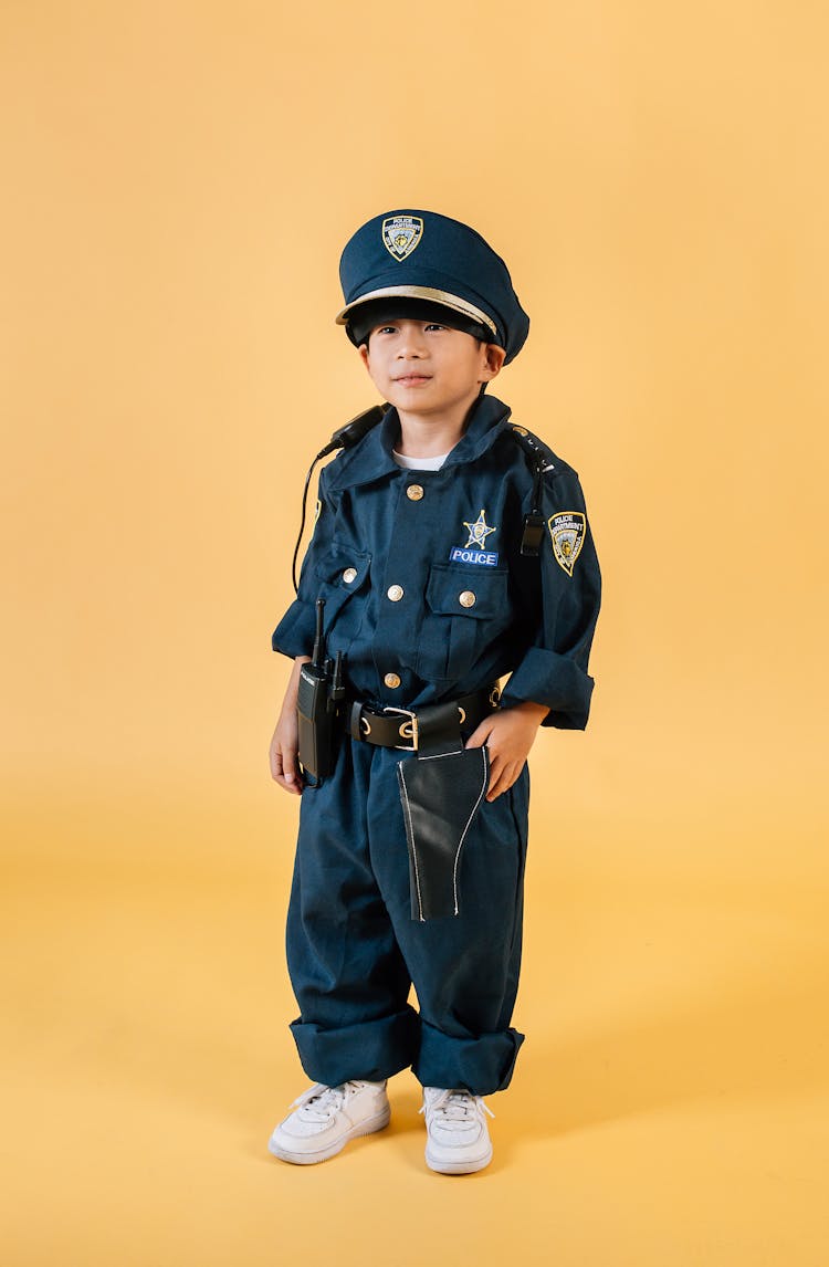 Asian Child In Policeman Costume In Studio