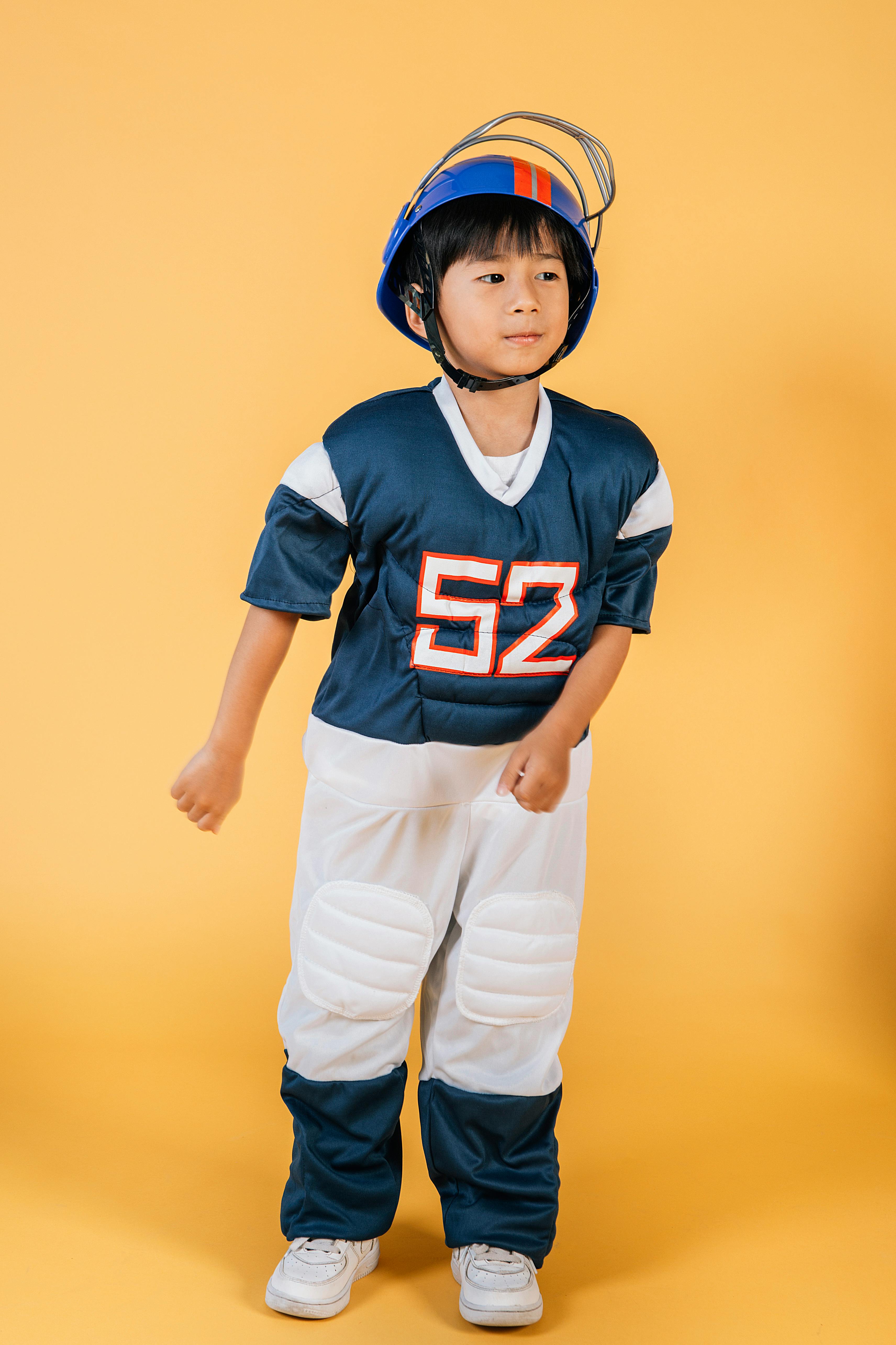 asian boy in american football player costume in studio