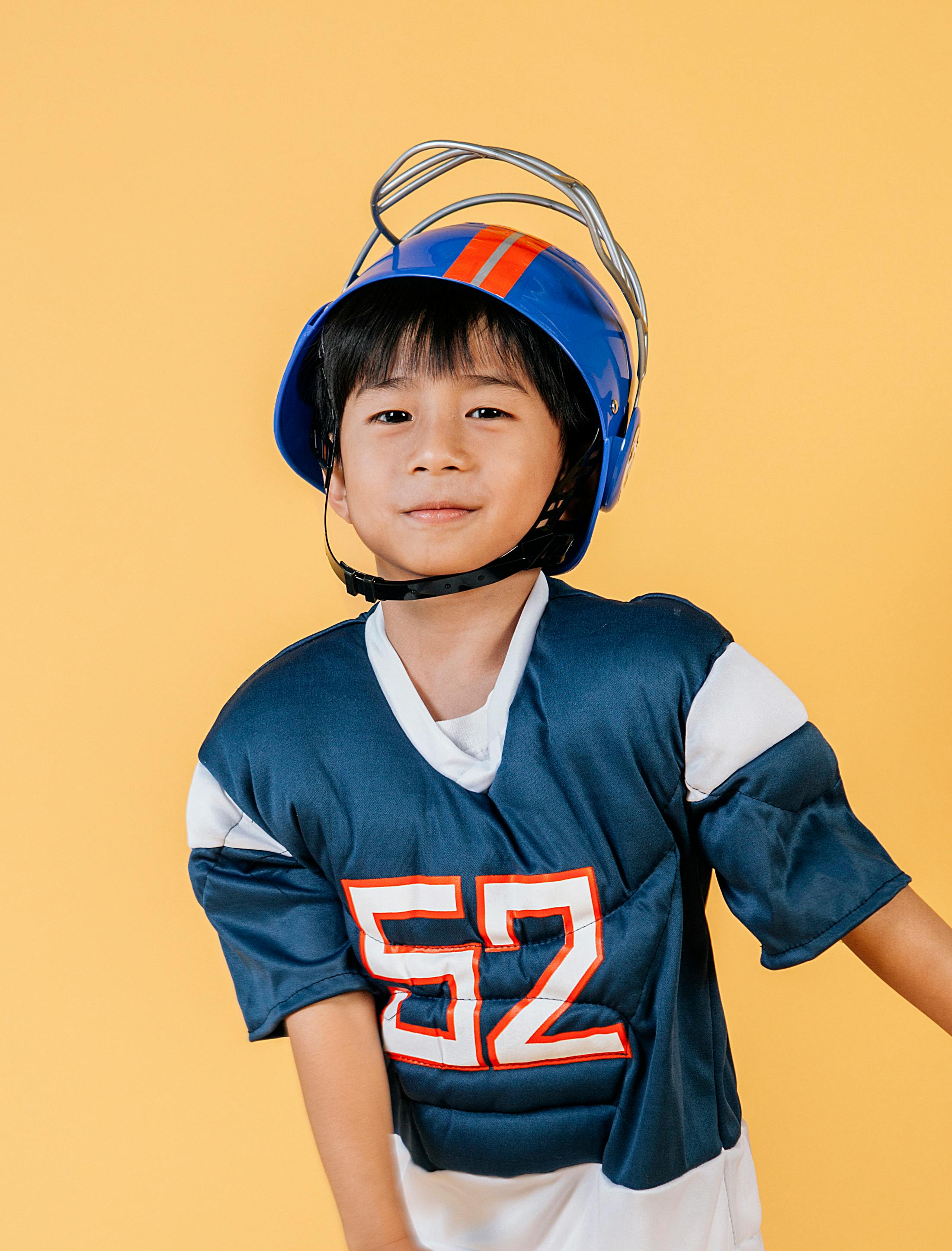 satisfied ethnic child in american football player costume and helmet
